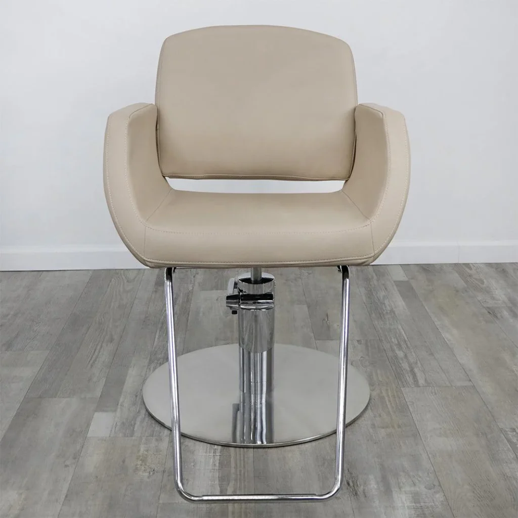 Sophisticated modern salon chairs arranged in a sleek, minimalist showroom. Plush, ergonomic leather seats in warm tones of brown and gray, complemented by polished chrome or matte black metal frames. Diffused natural light filters through large windows, casting a soft, ambient glow on the chairs. The layout is purposeful and visually arresting, showcasing the "James Barber Shop" brand's commitment to style and comfort. A sense of luxury and professionalism permeates the scene, hinting at the high-quality salon experience.