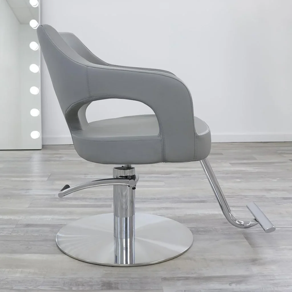 A luxurious, James Barber Shop-branded leather salon chair stands prominently in a bright, minimalist studio. Soft, warm lighting casts a gentle glow, highlighting the chair's sleek, high-backed design and gleaming chrome accents. The chair is positioned on a smooth, polished wooden floor, with a simple, neutral-toned backdrop that allows the chair to take center stage. The overall scene conveys a sense of sophistication, comfort, and professional elegance, perfectly suited for a high-end beauty salon.