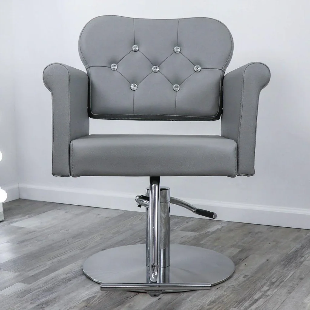 A sleek and modern reclining salon chair from the James Barber Shop, captured in a well-lit studio setting. The chair features a plush, adjustable backrest and footrest, allowing for versatile styling and maximum comfort. Smooth leather upholstery in a rich, deep brown hue adds a touch of sophistication, while the polished chrome frame provides a sturdy and durable base. The chair is positioned in the center of the frame, with a clean, minimalist background that allows the design to take center stage. Soft, directional lighting creates subtle shadows and highlights the chair's contours, giving it an inviting and luxurious appearance.
